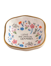 An antiqued trinket bowl with a floral pattern and the words 'I love that you're my grandma' printed inside.