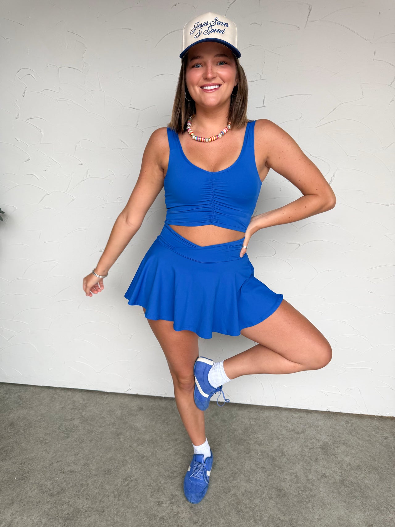 Girl in blue matching set in front of plain wall 