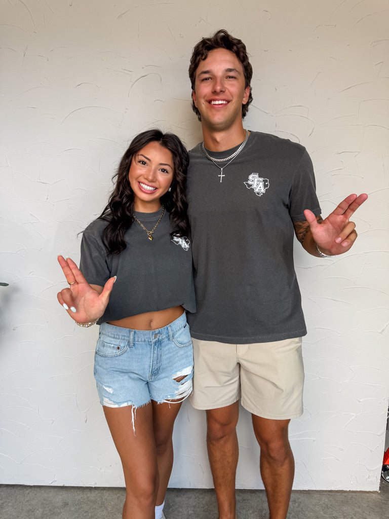 Two people posing together in front of a white wall