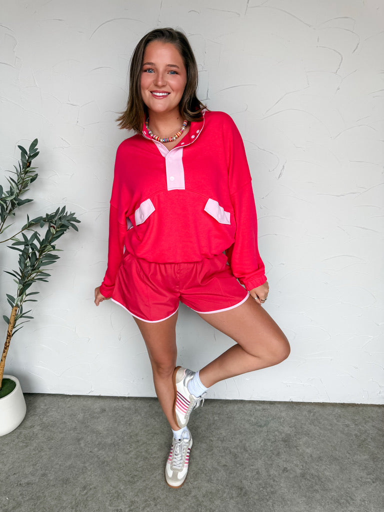 Girl in athletic set in front of plain wall 