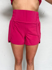 Person wearing pink shorts and a matching top on a white background