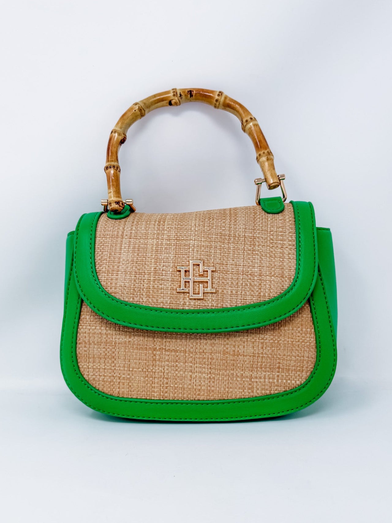 Handbag with green trim and bamboo handle on a white background