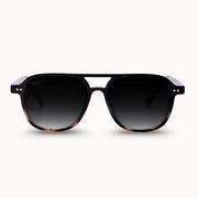 Sunglasses with a tortoiseshell frame and dark lenses on a white background