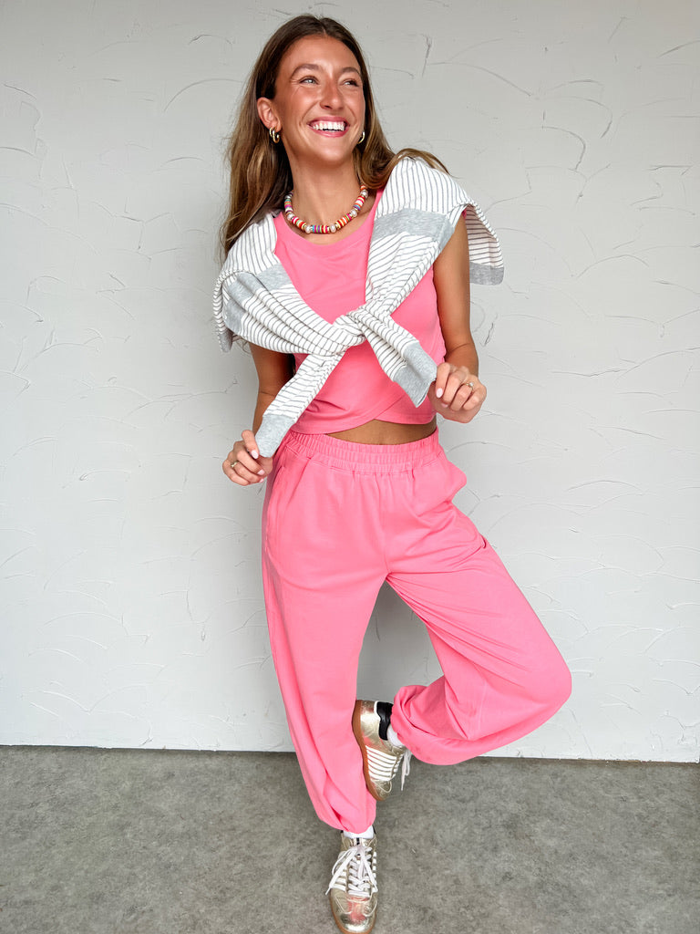 Girl in pink matching set in front of plain wall