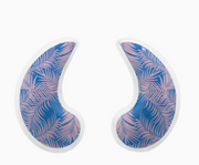 Two crescent-shaped gel pads with a blue and pink palm leaf pattern, outlined in white, shown on a plain white background.