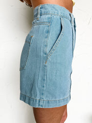 Light blue denim shorts worn by a person on a white background