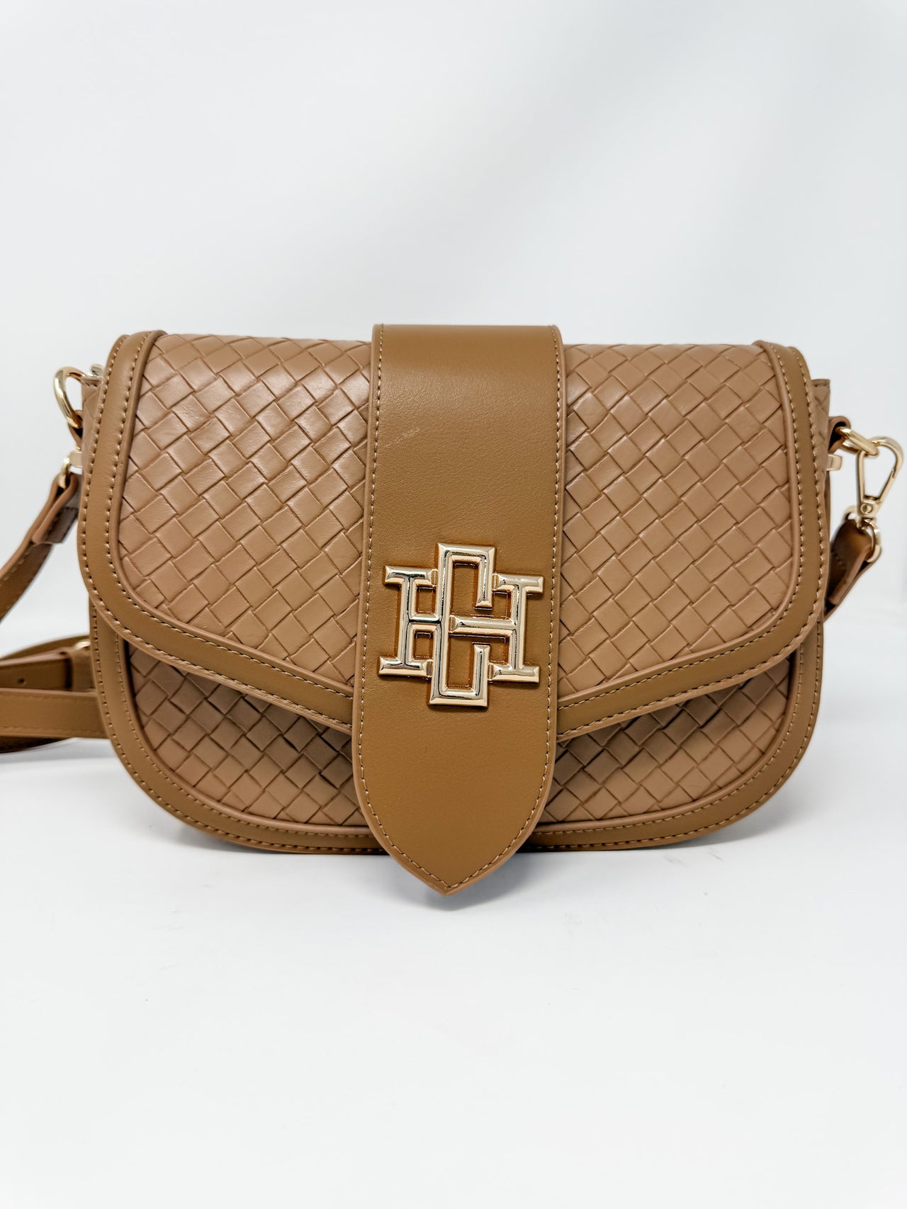 Brown woven handbag with a gold logo on a white background