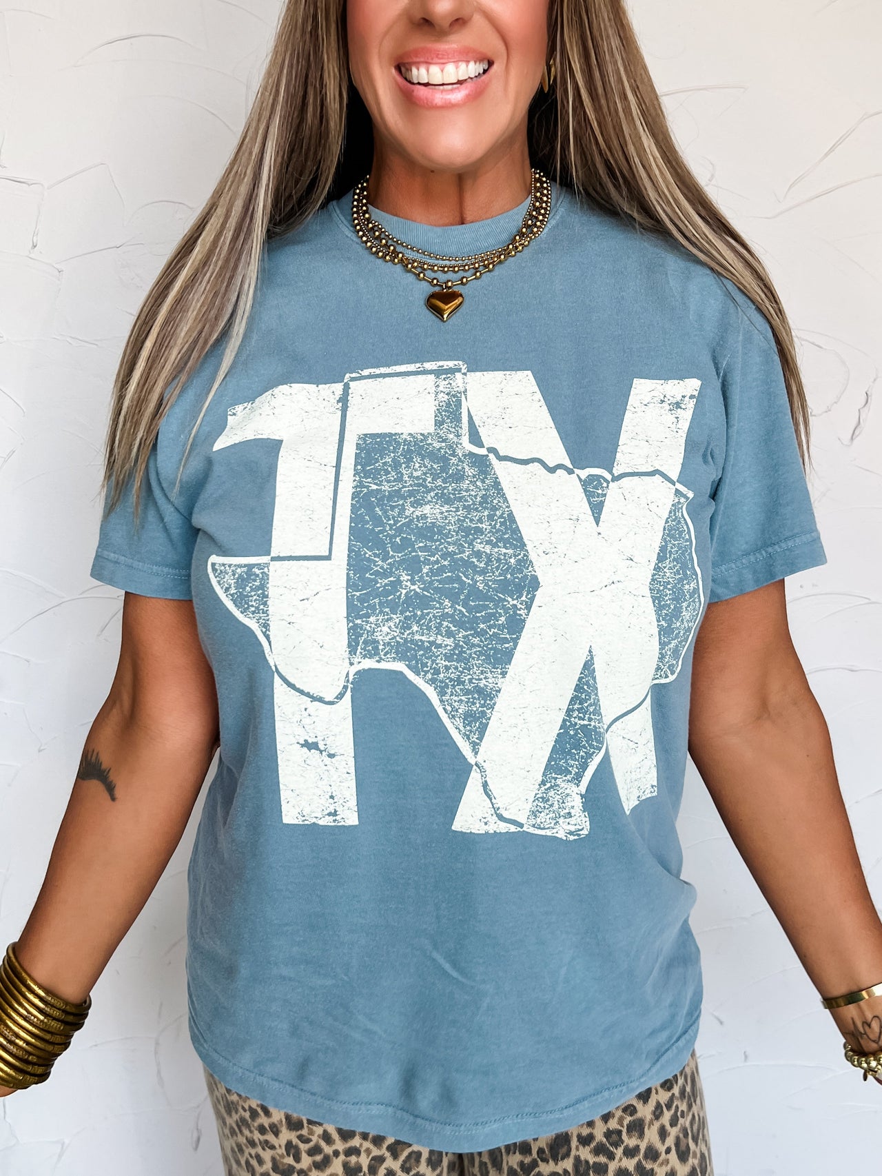 Woman wearing a blue t-shirt with a white graphic design against a white background