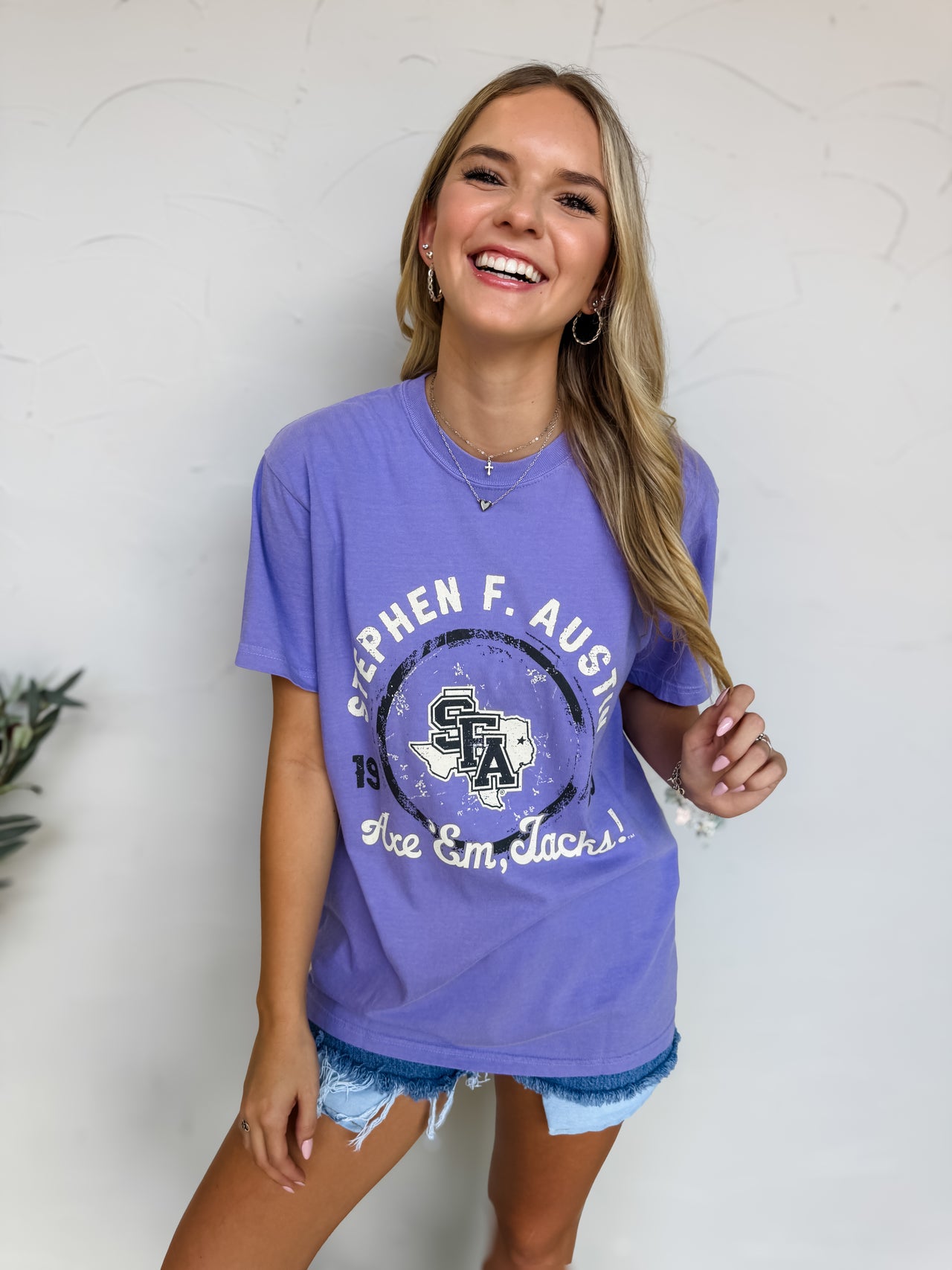 Woman wearing a purple Stephen F. Austin t-shirt against a white background