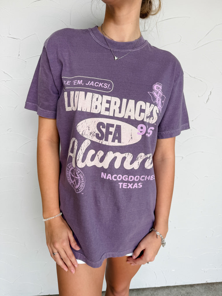 Person wearing a purple 'Lumberjacks SFA Alumni' t-shirt against a white background