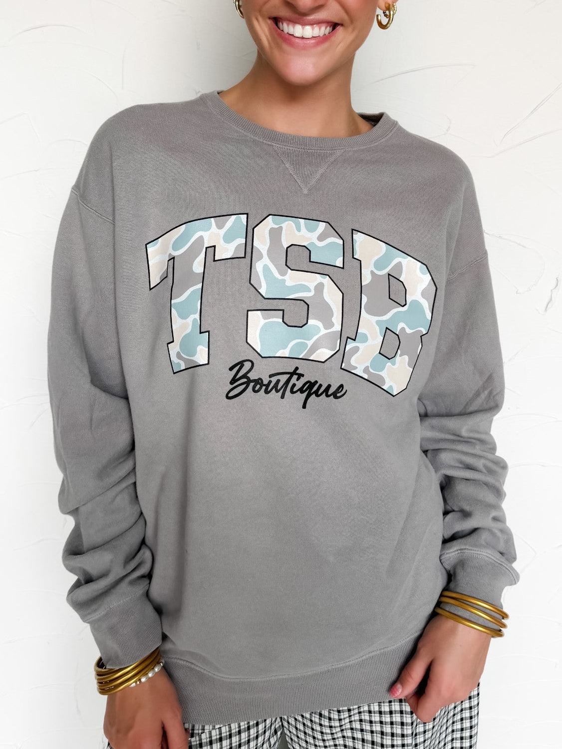 Woman wearing a gray sweatshirt with 'TSB Boutique' text on a white background