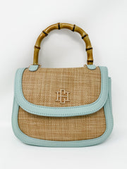Handbag with bamboo handle and light blue leather accents on a white background