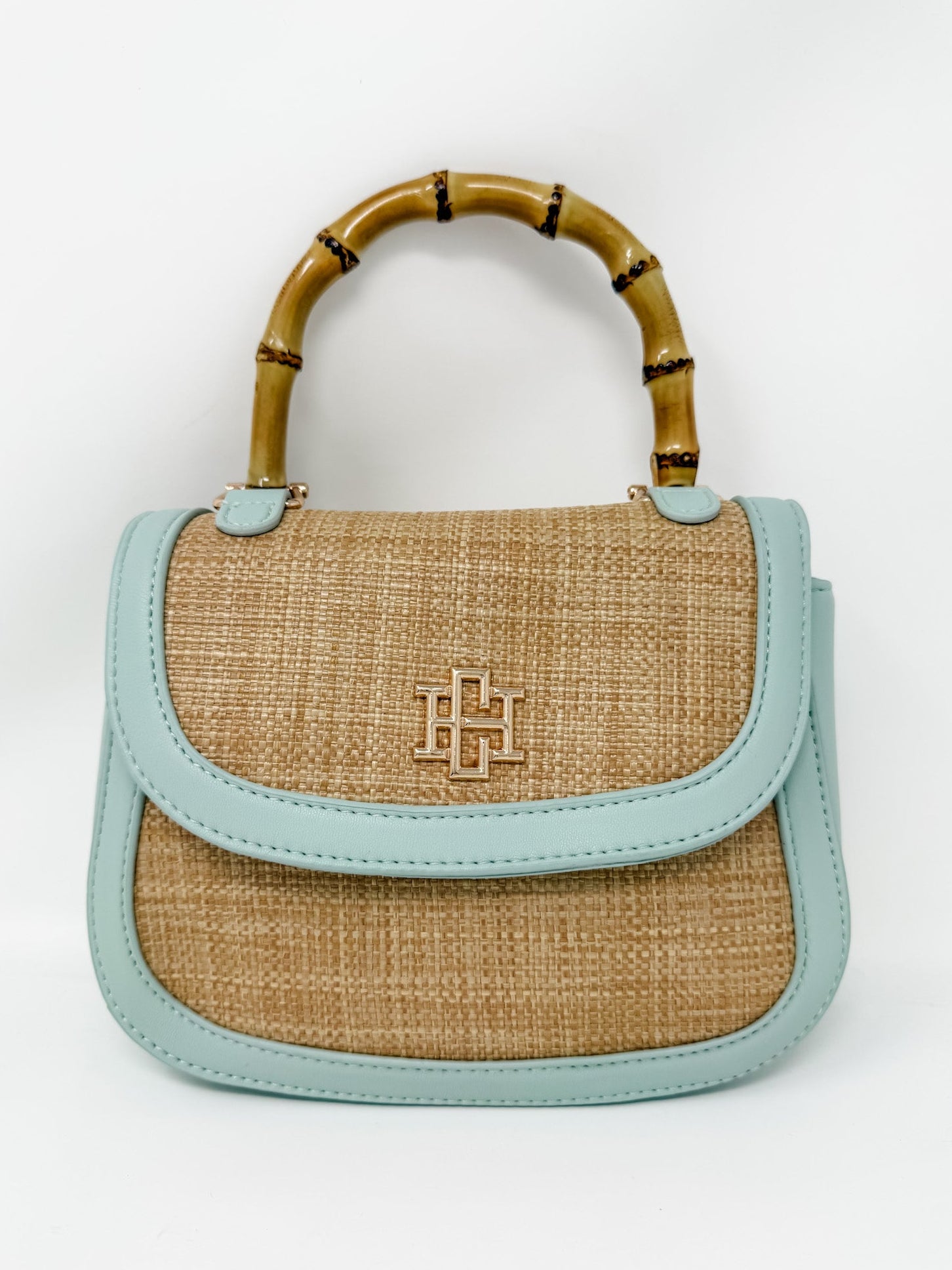 Handbag with bamboo handle and light blue leather accents on a white background