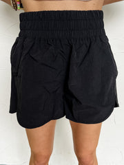 Person wearing black running shorts against a white background