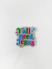 A car air freshener featuring a white glitter background shaped around the words "Y'all need Jesus" in a colorful retro font, shown against a plain white background.
