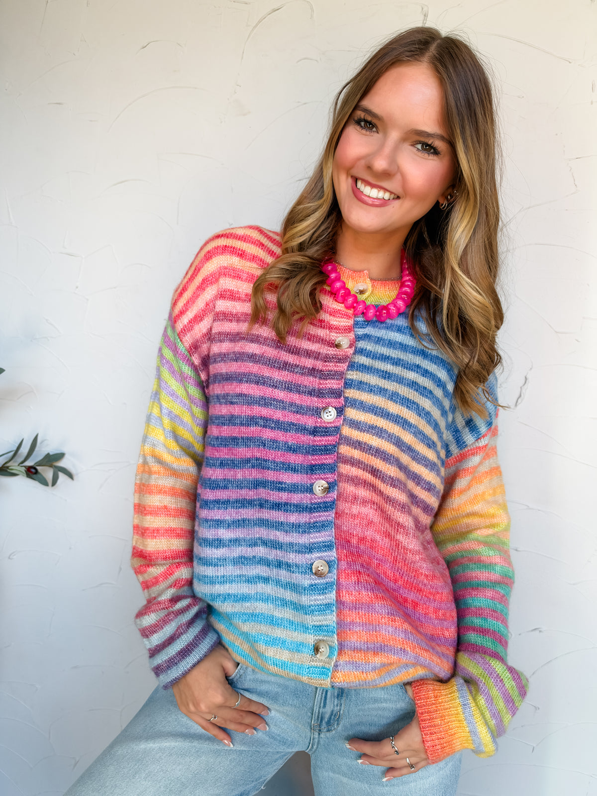 Catie modeling the Bucketlist Space Dye Striped Button Down Cardigan, worn open over a white cropped top and light-wash jeans. Features multicolored horizontal stripes, long sleeves, and ribbed trim. Made of 47% acrylic, 44% polyester, 6% nylon, and 3% wool.


