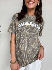 Person wearing a camouflage t-shirt with 'LUMBERJACK' text against a white background