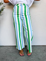 Girl in stripe pants in front of plain wall 