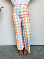 Person wearing colorful Gingham pants against a white wall.