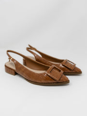 A pair of Pierre Dumas brown croc-embossed pointed-toe slingback flats displayed against a solid white background. The shoes feature an adjustable ankle strap with a small gold buckle, a low block heel, and a large matching brown square buckle detail across the toe box.