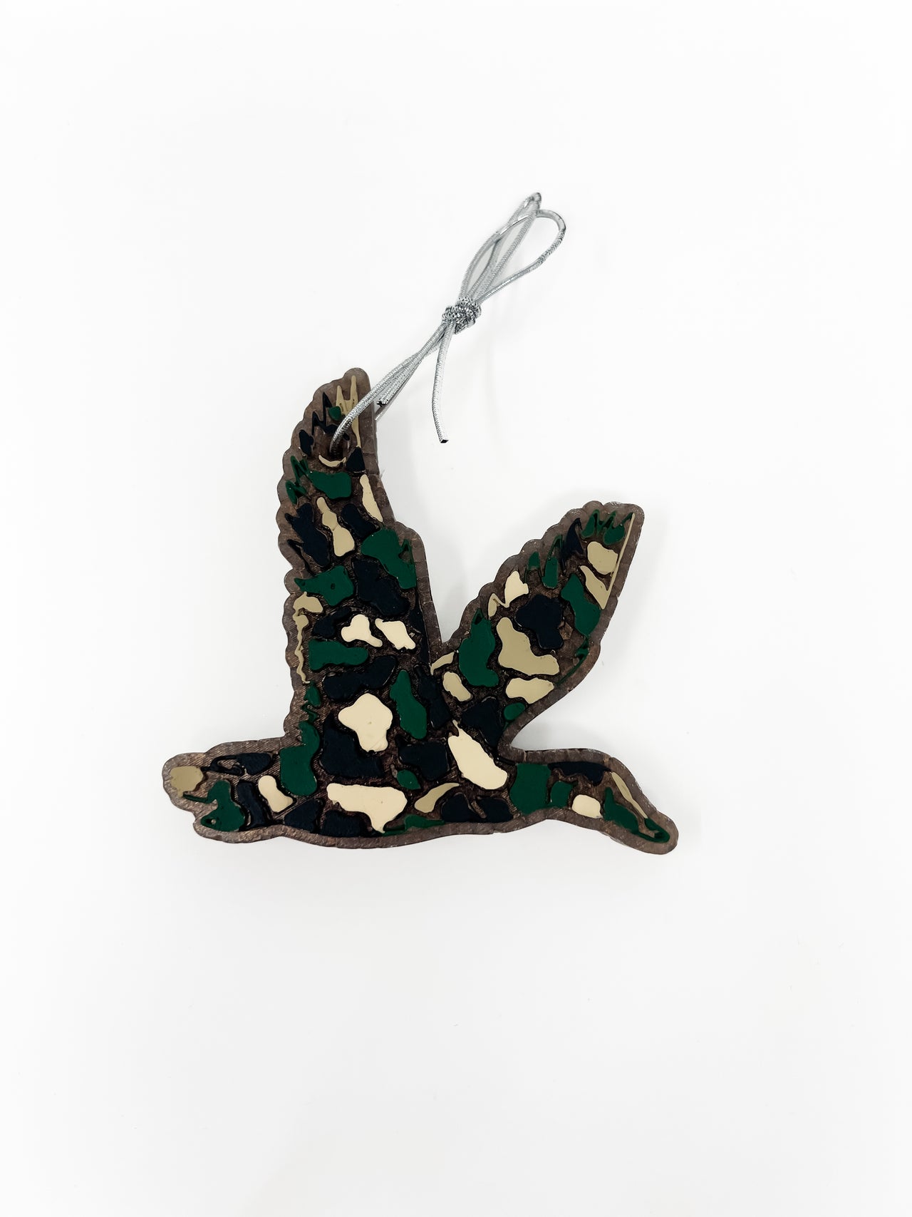 This flying duck car freshie features a distinct, textured camouflage pattern detailing the bird's silhouette in flight. It comes ready to hang from your rearview mirror with an attached metal hanging hook. Scents vary.