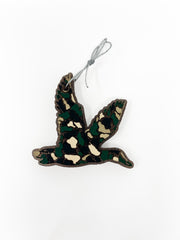This flying duck car freshie features a distinct, textured camouflage pattern detailing the bird's silhouette in flight. It comes ready to hang from your rearview mirror with an attached metal hanging hook. Scents vary.