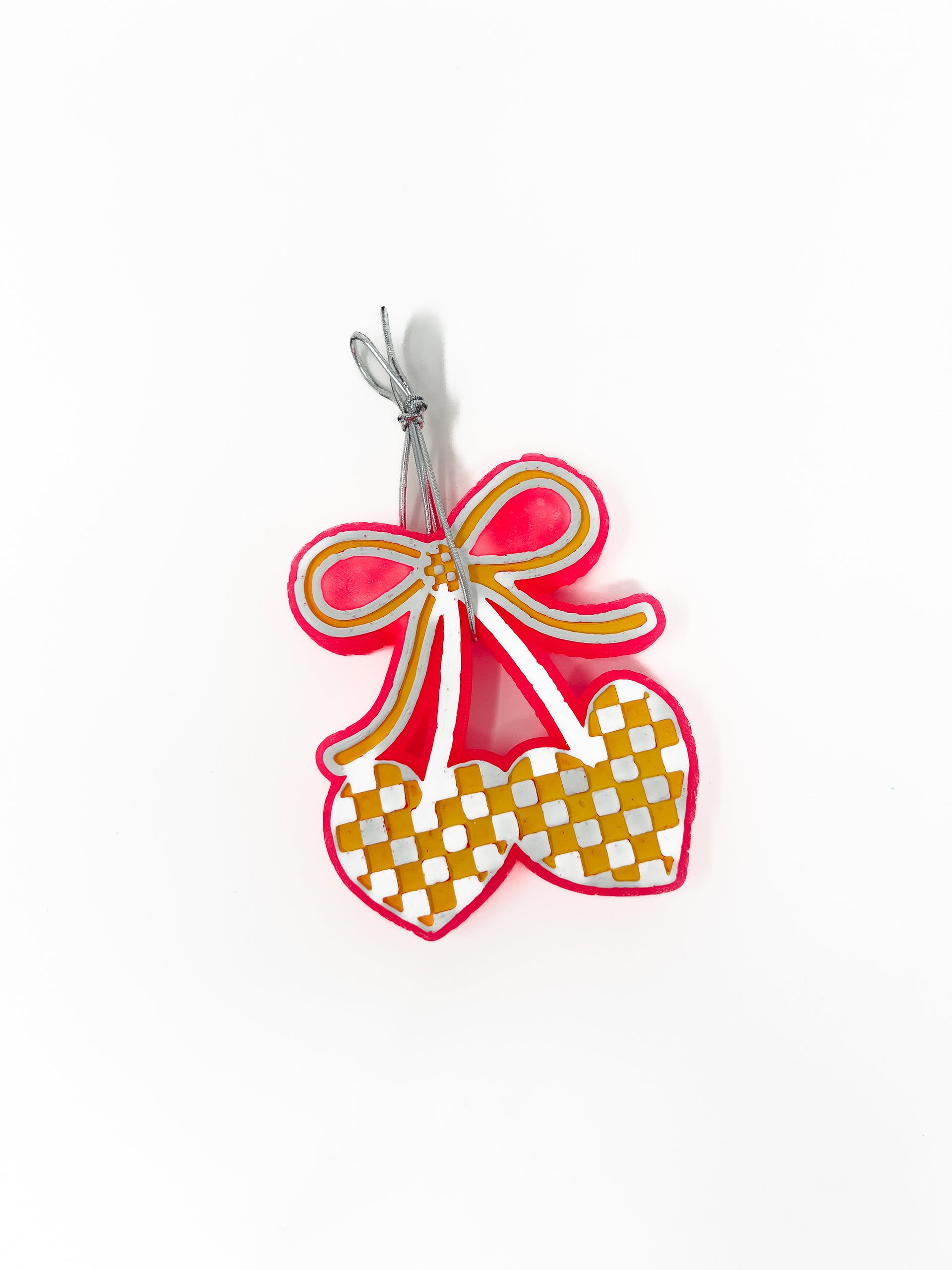 Decorative ornament shaped like a checkered shoe with a bow on a white background