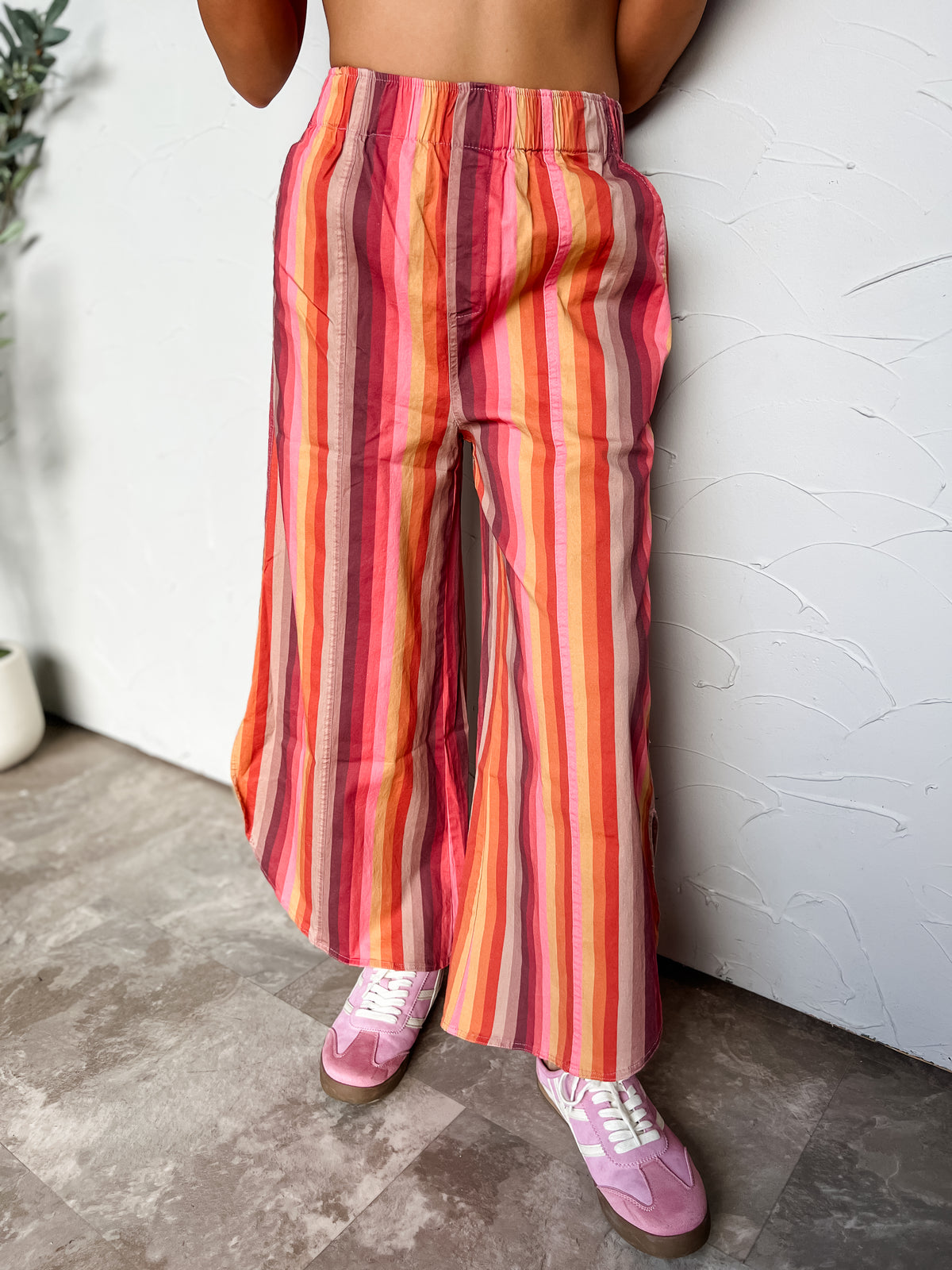 Mustard multicolor striped wide-leg jeans with an elastic waistband, side pockets, and curved hems with side openings, made of 97% cotton and 3% spandex.