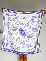 A white square scarf or bandana with a purple border and purple printed illustrations, held up by a person against a light gray wall. The design features the letters 'SFA' in a purple outline shape resembling Texas, surrounded by small drawings of hands, hearts, stars, and text reading 'One Team'.
