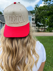 Person wearing a cap with 'MERICA' on it outdoors