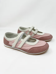 A top-down view of a pair of Le Sheela pink Mary Jane sneakers on a white background. The shoes display two parallel off-white velcro straps across the instep, an off-white collar trim, decorative athletic stitching around the rounded mauve toe box, and light gray insoles.