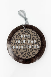 This "Mind Your Own Motherhood" car freshie features a sassy, round design with a bold leopard print center and block lettering, all framed by a smooth, circular outer border. It comes ready to hang from your rearview mirror with an attached silver string. Colors and scents vary.