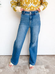 Rear view of Risen My Happy Place high-rise wide-leg jeans in medium blue denim, made from 96% cotton, 2% polyester, and 2% spandex, with back welt pockets and finished hems.