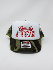 A camouflage trucker hat with a white front panel featuring red embroidered text that reads 'Give Me A BREAK!'. The hat has green, brown, and black camouflage pattern panels on the sides and brim, with a small brand patch on the brim.