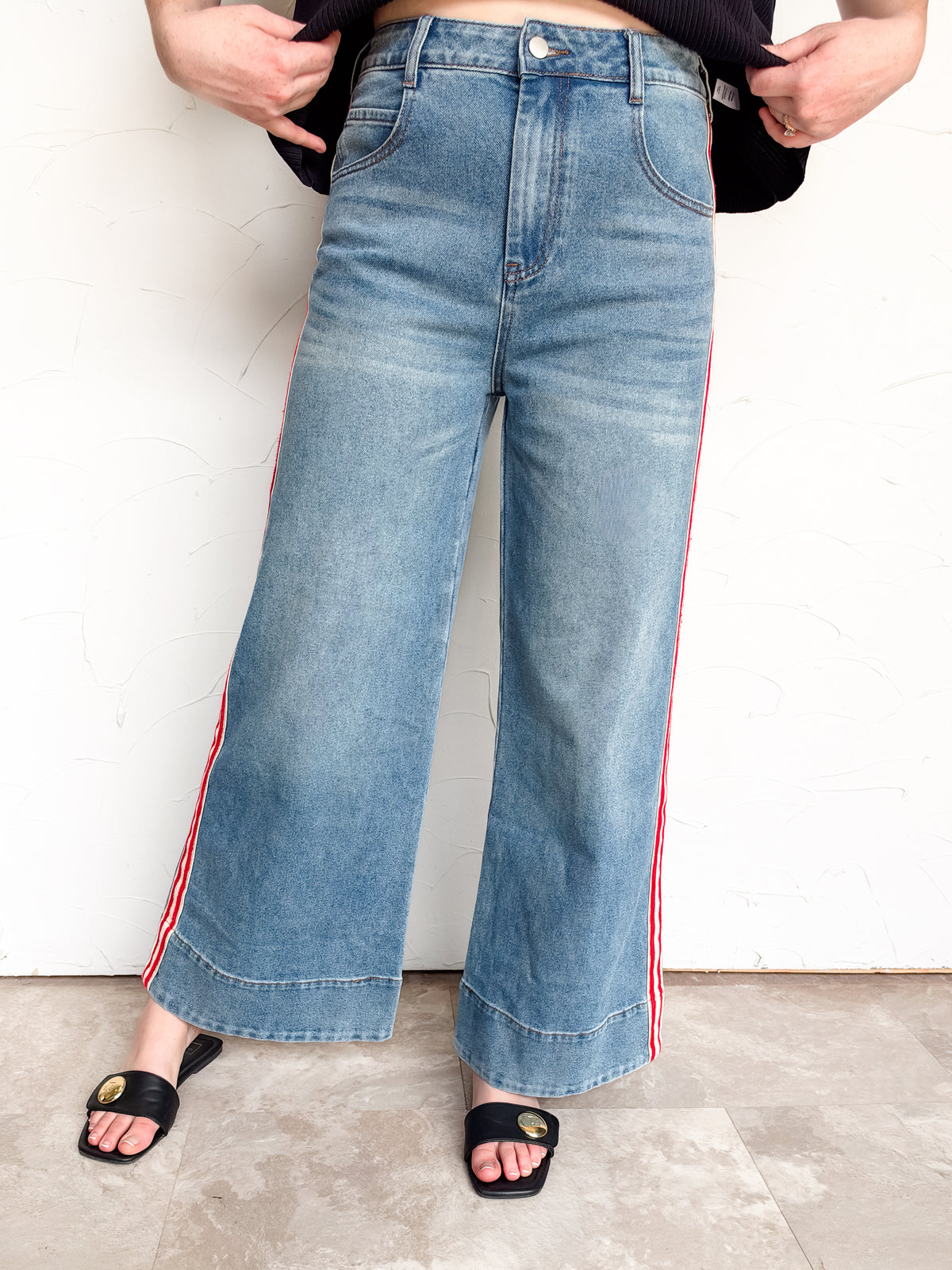  eesome The Rundown wide-leg denim pants with red-and-cream side stripes and deep stitched hems, made from 66% cotton, 27% polyester, 6% viscose, and 1% spandex.⠋