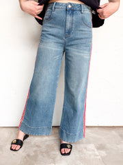  eesome The Rundown wide-leg denim pants with red-and-cream side stripes and deep stitched hems, made from 66% cotton, 27% polyester, 6% viscose, and 1% spandex.⠋