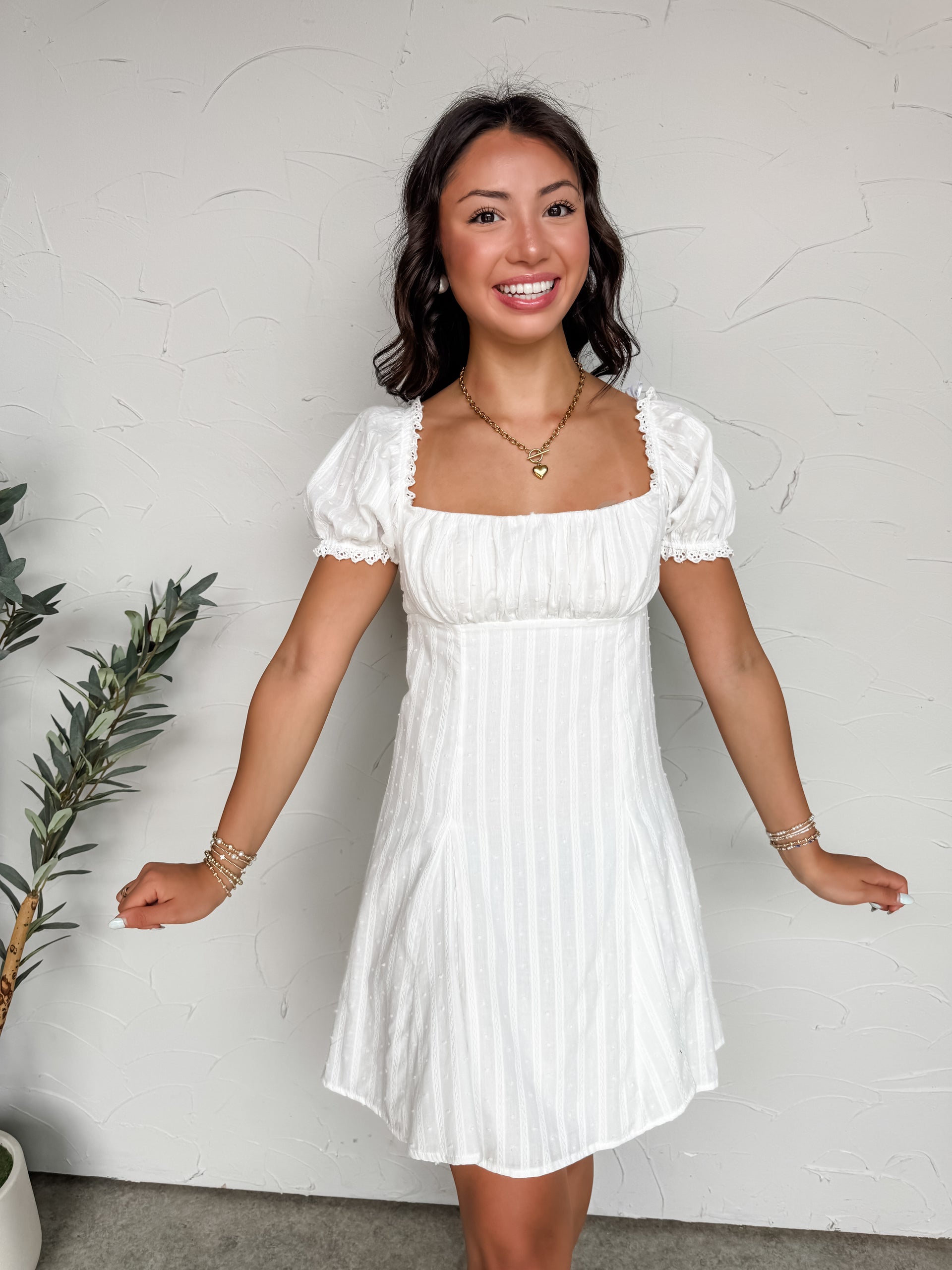 Woman wearing a white dress against a plain background