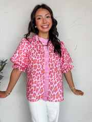 Woman wearing a pink floral blouse against a white background