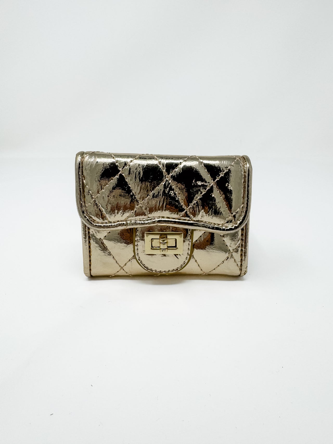 A small, compact metallic gold wallet with a high-gloss finish displayed against a solid white background. The wallet features a diamond-quilted pattern, a curved front flap, and a polished gold-toned metal turn-lock closure.