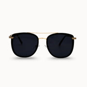 Sunglasses with black lenses and gold frame on a white background