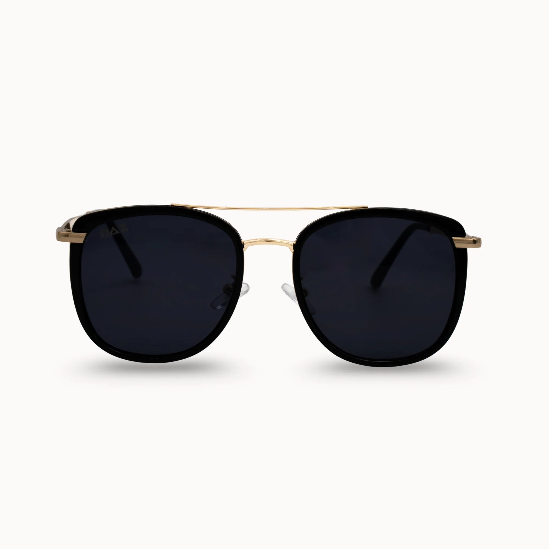 Sunglasses with black lenses and gold frame on a white background