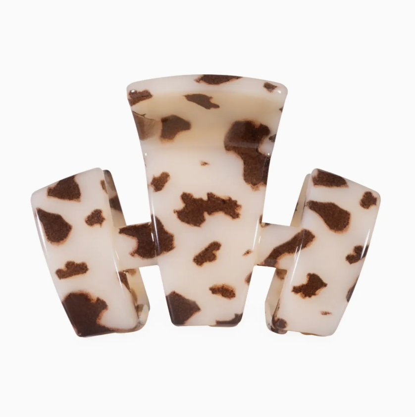 A three-prong hair claw clip made of glossy resin with a brown and cream tortoiseshell pattern, shown against a plain white background.