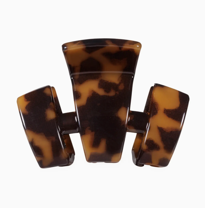 A three-prong hair claw clip in a glossy tortoiseshell pattern, featuring dark brown and warm tan tones, set against a plain white background.