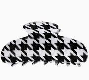 A large claw hair clip with a bold black and white houndstooth pattern, shown against a plain white background.
