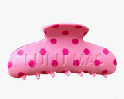 A pink hair claw clip with darker pink polka dots and the brand name 'LULU MAC' embossed on the front, set against a plain white background.