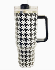 A tall travel tumbler with a black and white houndstooth pattern, featuring a black handle, clear lid, and straw on a white background.
