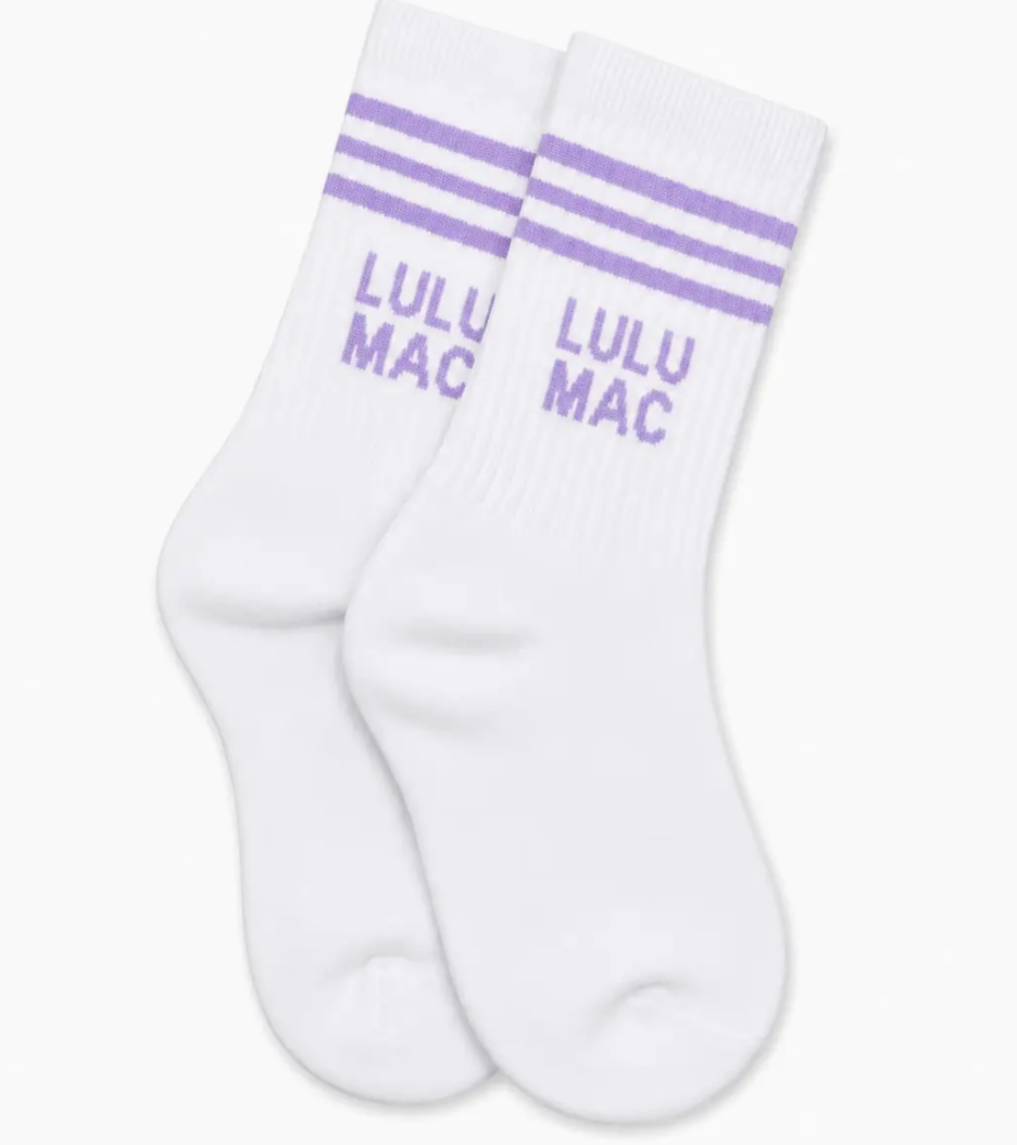 A pair of white crew socks with three purple stripes near the cuff and the purple text 'LULU MAC' printed on the side, shown on a clean white background.