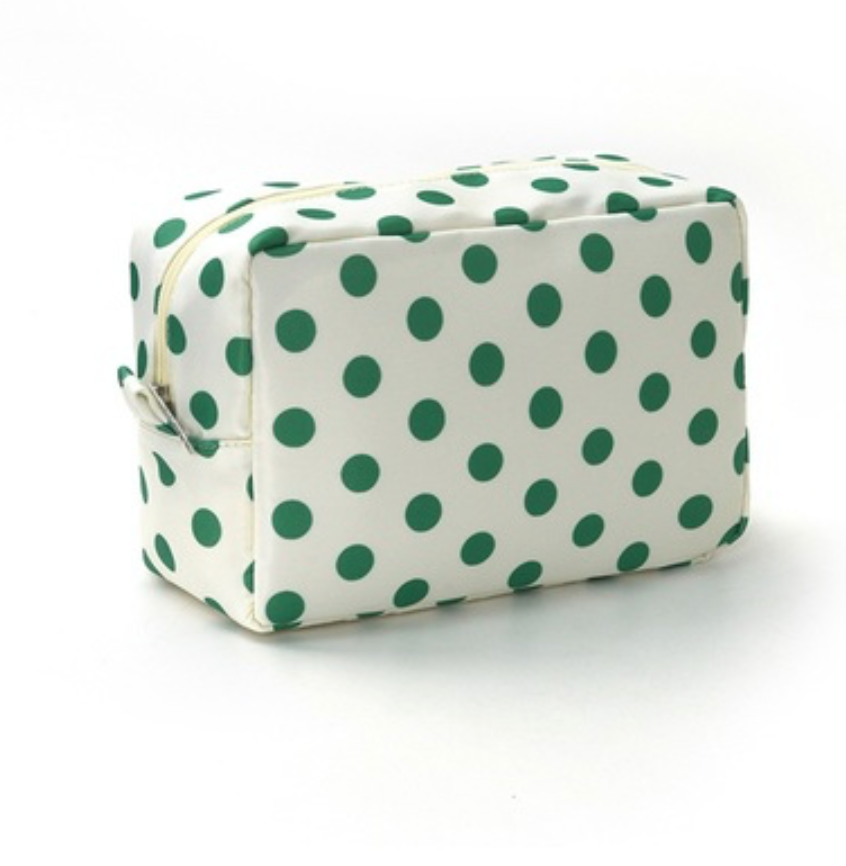 A rectangular zippered cosmetic bag with a white background and green polka dots, shown on a clean white studio background.