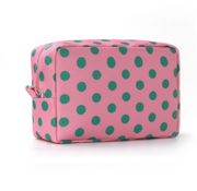 A pink cosmetic pouch with a green polka dot pattern, shown on a clean white background.