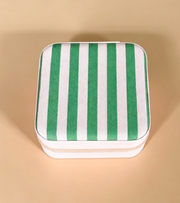 A square zippered storage box with a green and white striped fabric lid, set against a solid beige background.